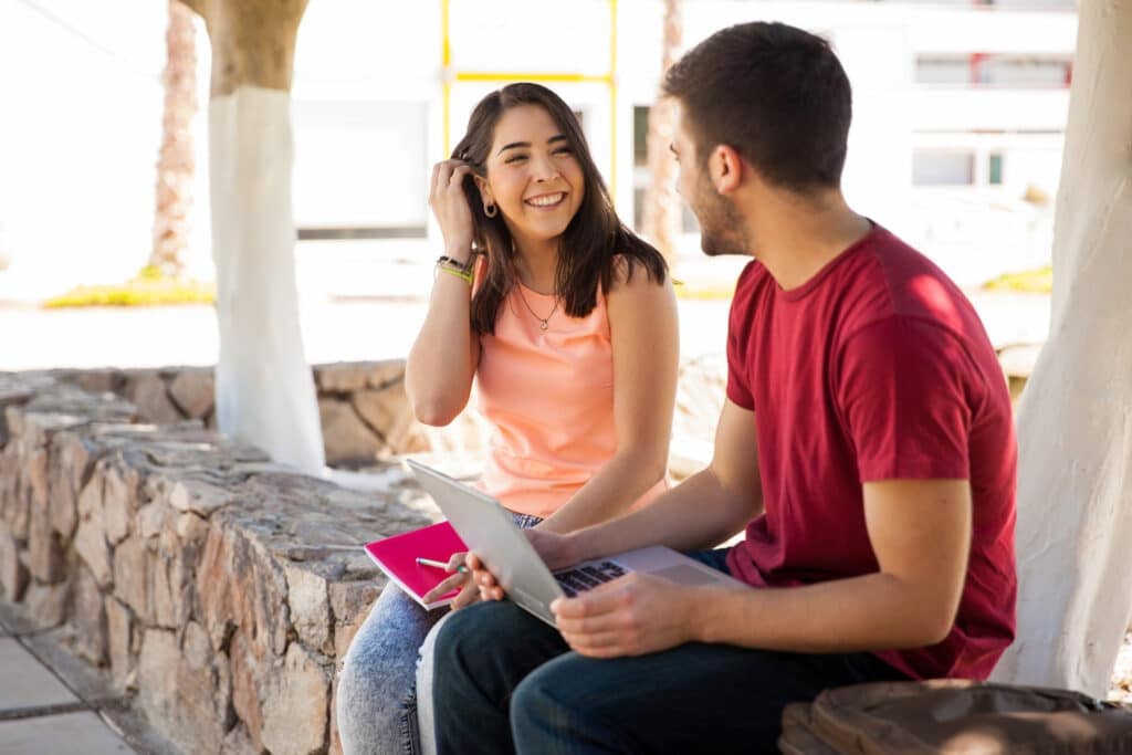 Beautiful Latin college student flirting and talking to a guy she likes at school.