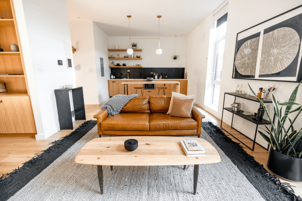 Living room with brown leather couch and wooden table in an Airbnb rental.